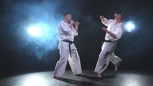 Kampfsportmeister auf dunklem Hintergrund Starke Mannkämpfer im weißen Kimono für Karate-Kampfkünste