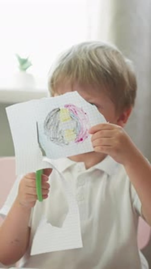 Diligent Boy Cuts Out Circle with Drawing of Copybook Page