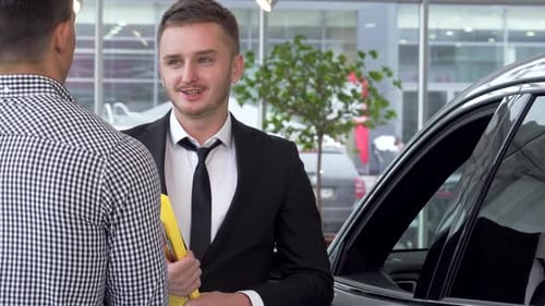 Car Salesman Talking to Client in Dealership