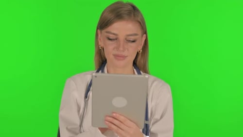 Portrait of Female Doctor Using Digital Tablet on Green Background