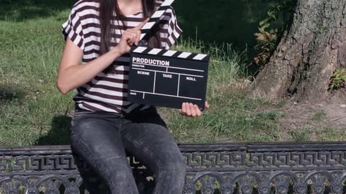Thinhaired Girl with Clapboard in the Park