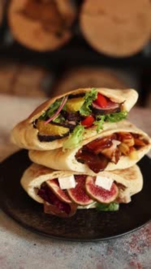 pitas with different fillings on a black plate in a restaurant