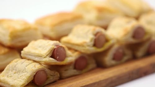 Blätterteig mit Hotdog serviert auf dem Holzbrett