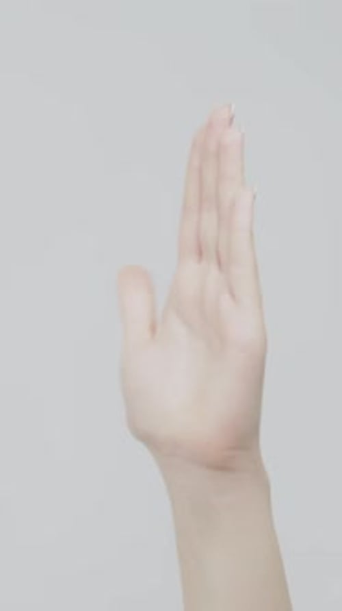 Hand wiggling fingers against gray background