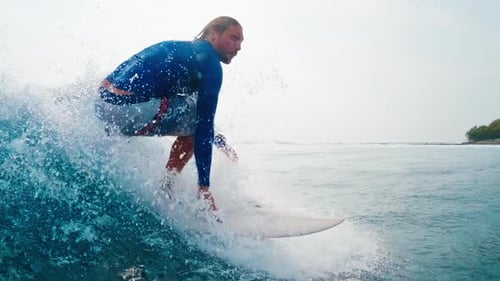 Surfing in Maldives. Man surfs the ocean wave in tropics
