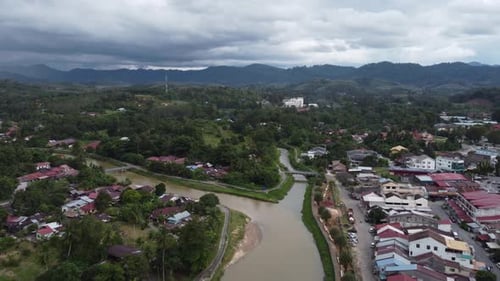 Bird's-eye perspective of river winding through traditional Malaysian village
