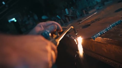 Industrial Manual Cutting of a Metal Part with an Oxyfuel Cutter in a Workshop