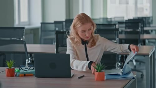 Woman Reacts to News at Desk in Modern Office