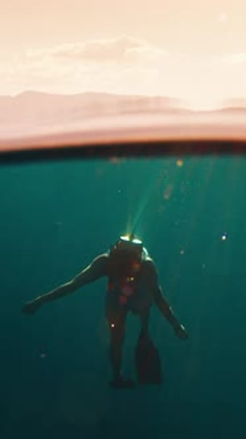 Woman Freediver Swims Underwater in the Sea at Sunset and Relaxes and Floats Beneath the Surface