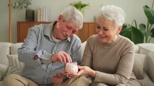 Saving Money Investment for Future Senior Adult Mature Couple Holding Piggy Bank Putting Money Coin