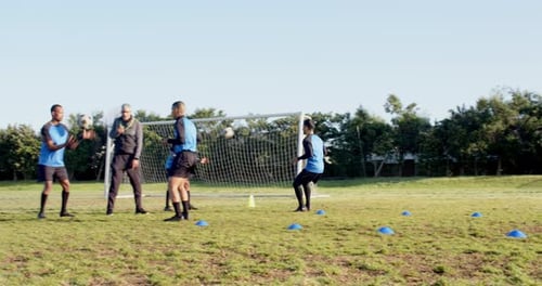 Playing soccer, athletes training on field with cones and goal in background