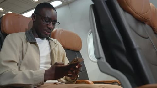 Passenger businessman using mobile phone test wifi connection in plane during flight