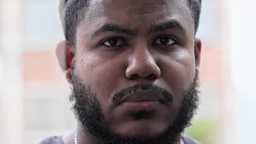 Calm And Focused Black Man With Beard Staring Into Camera With Intense Serious Expression In