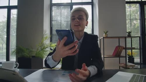 Woman in Office Talking on Smartphone