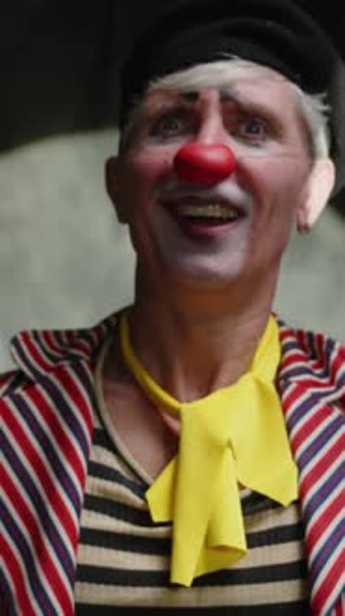 Smiling Clown with Red Nose Plays Party Horn