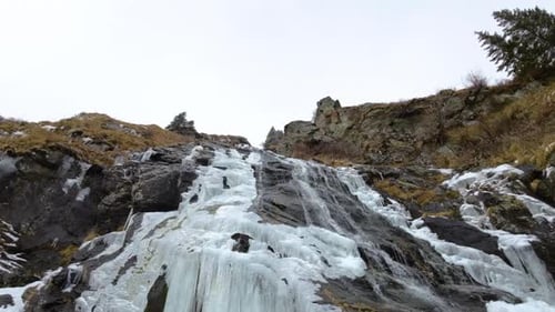 Cascada congelada en la montaña. Vista de ángulo bajo de la cascada de hielo.