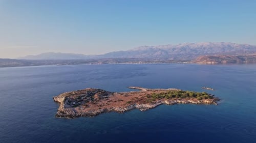 Luftaufnahme einer ruhigen Insel, umgeben von ruhigem blauem Wasser in der Abenddämmerung