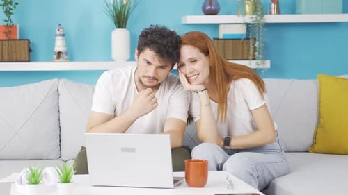 Loving Couple Using Laptop on Sofa at Home