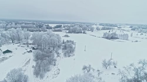 Fields by the house are covered with snow during winter.