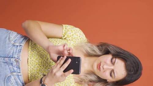 Annoyed Woman Typing on Mobile Phone Vertically