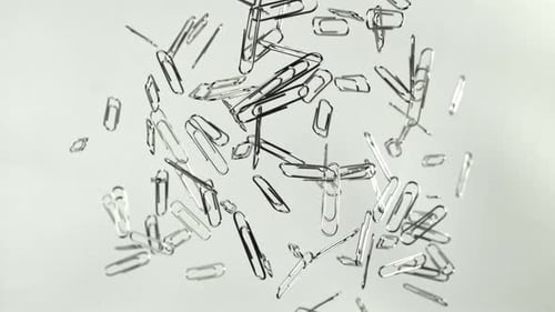 Shiny Metal Paperclips Floating on White Background