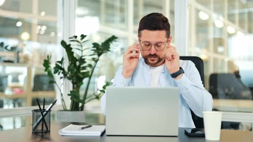 Focused Businessman Working on Laptop in Modern Office
