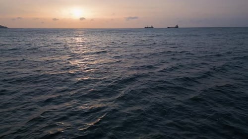 Aerial View of Calm Sea Sunset with Cargo Ships on the Horizon