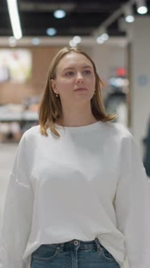 Shopper Walking Through Fashion Store Observing Clothing Displays