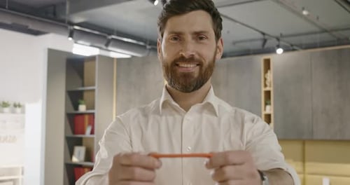 Male Seller with Beard Standing in Furniture Store Holding Giving Showing Bag