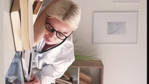 Woman Doctor Reading a Book in Office