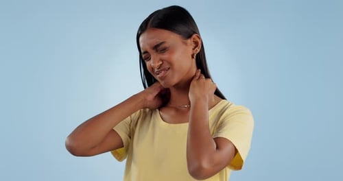 Stress, neck pain and face of Indian woman in studio with inflammation, sprain