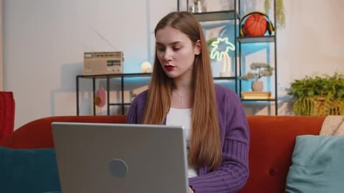 Woman Uses Laptop at Home on Sofa