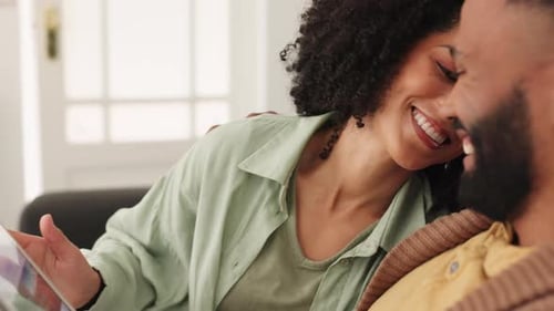 Tablet, love and relax with a black couple doing an online search while sitting on the sofa