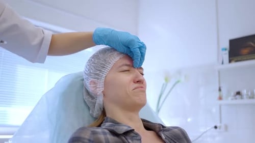 Woman Receiving Forehead Treatment in Doctor's Office