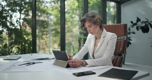 A Young Woman Architect Holding and Working with Tablet Pc Pad at Her Work Office with Big Sunlight