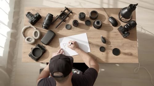 Freelance Videographer at Work Desk Writes Inscription on Paper Part Three 3