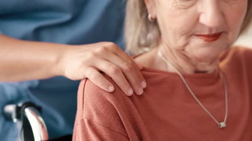 Caregiver Comforts Senior Woman in Hospital Setting