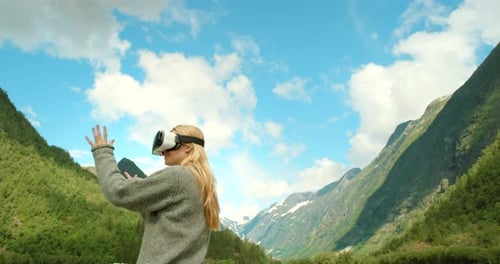 Woman Using VR Headset in Mountainous Landscape
