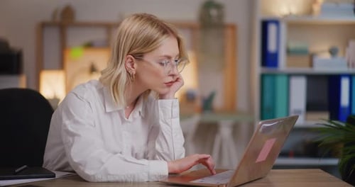 Besorgte überarbeitete Frau arbeitet abends am Laptop