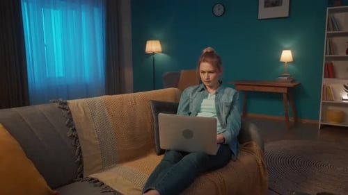 Woman Working on Laptop While Sitting on Couch