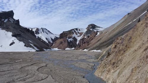 Ascending forward drone view over Landmannalaugar's rhyolite mountains in Brandsgil valley, showcasi