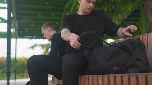 Boxers Organizing Gear Outdoors Individuals Arrange Boxing Gloves on Park Bench Outdoors Pair of Men