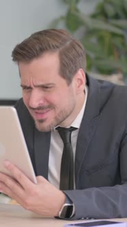 Businessman Upset by Loss on Tablet, vertical video