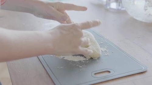 In a Warm and Inviting Kitchen Scene an Artisan Baker is Shown in a Closeup Shot Expertly Kneading
