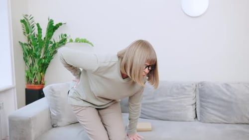 Woman Suffering From Back Pain at Home