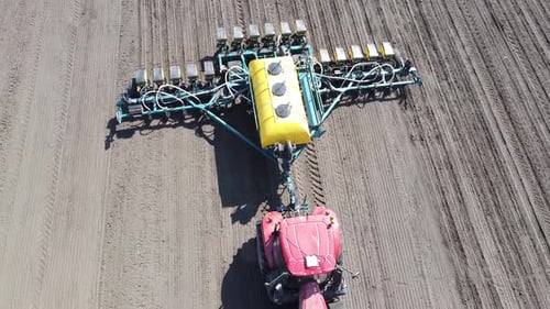 Tractor with yellow seeder working on the field in Ukraine OA Lexa