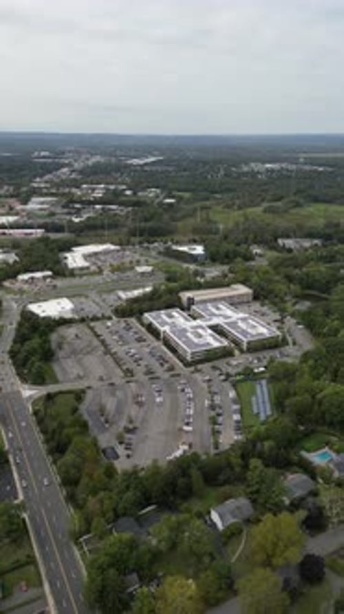 Panoramic aerial perspective of a modern corporate building complex with solar panels on the roof,