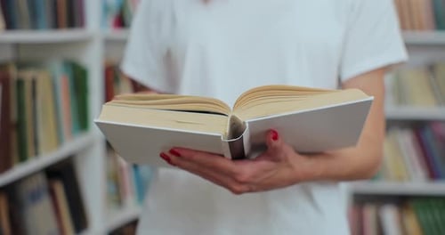 Close Up Shot of Unrecognizable Woman Student Reading Book Searching for Information at University