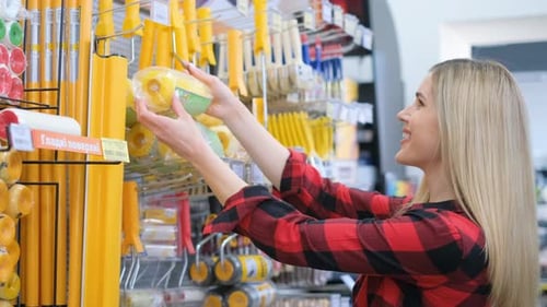 a Woman is Shopping for Tools in a Hardware Store