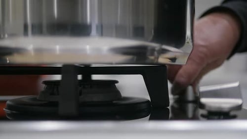 Close-up of stovetop burner while turning on a modern gas stove.
